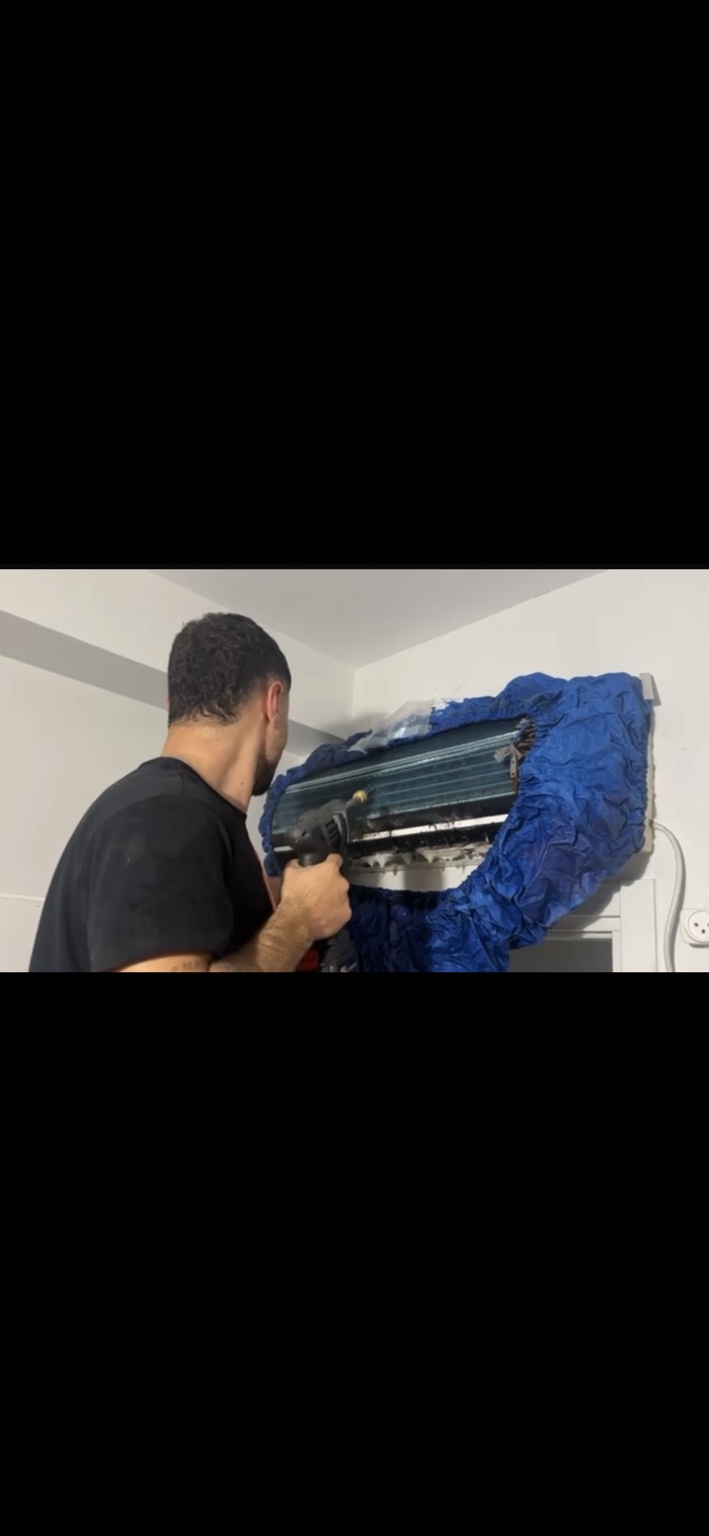 ניקוי סוללת מזגן עילי במהלך עבודה של מזגן מבריק